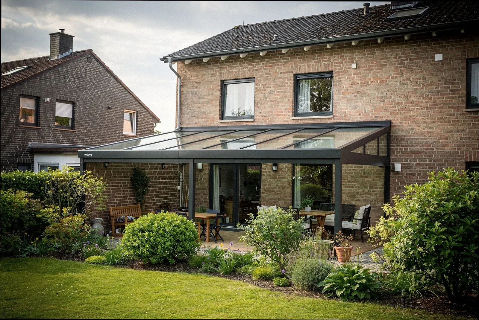 Moderne Terrassenüberdachung mit Glasdach an einem Wohnhaus in Augsburg